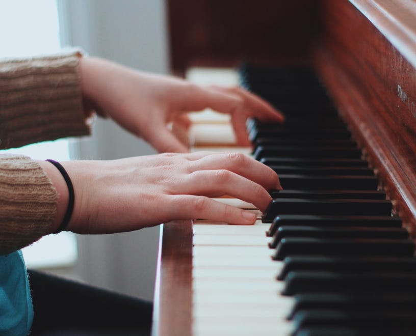 Handen op het klavier van een piano. Afbeelding op de site van Kuijper Pianoservice