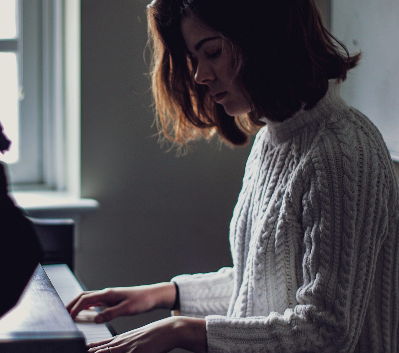 Jong meisje achter de piano op de website van Kuijper Pianoservice in Assen